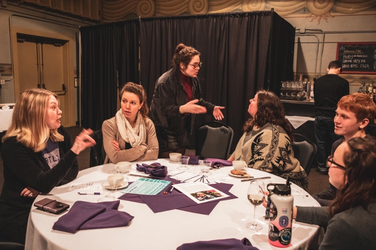 students and staff conversing at table