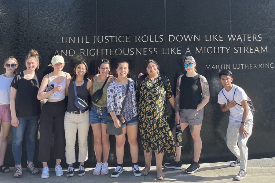 Students pose in front of a memorial to Dr. Martin Luther King Jr.