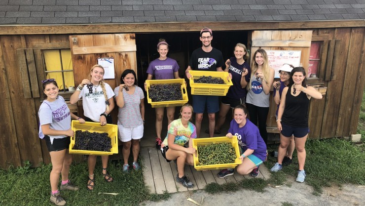 Stonehill College students holding produce