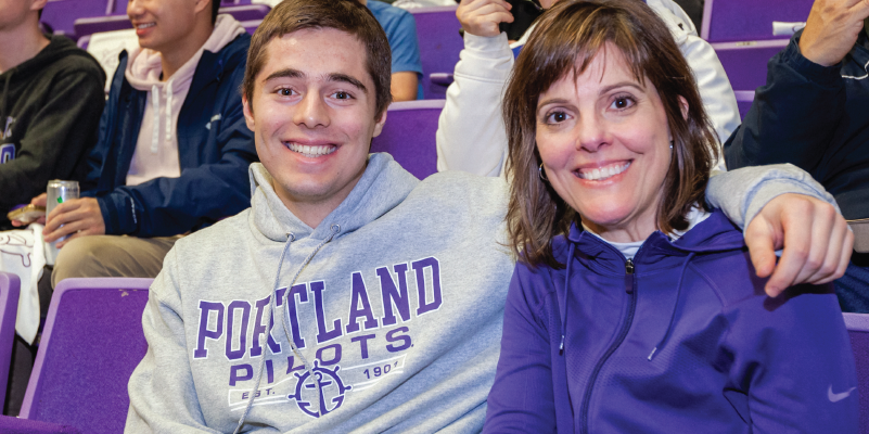 Mom and son in Pilot gear at a basketball game