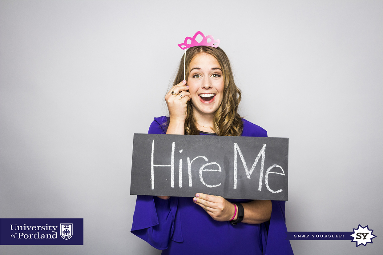 student holding sign saying hire me