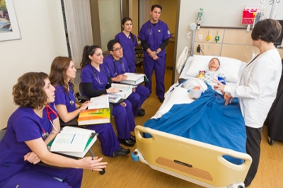 nursing students around a hospital bed