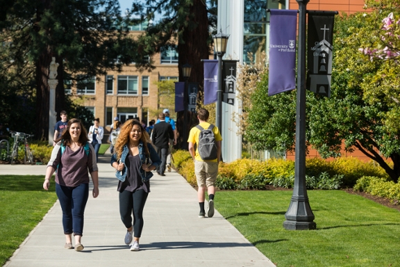 Two female students walking on a campus path