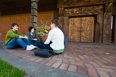four students sitting on the ground talking