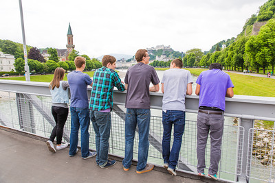 six students stand with their backs to the camera looking over a bridge