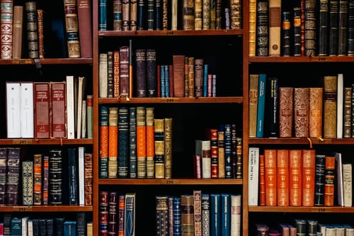 Pictured is a bookshelf full of colorful books. 