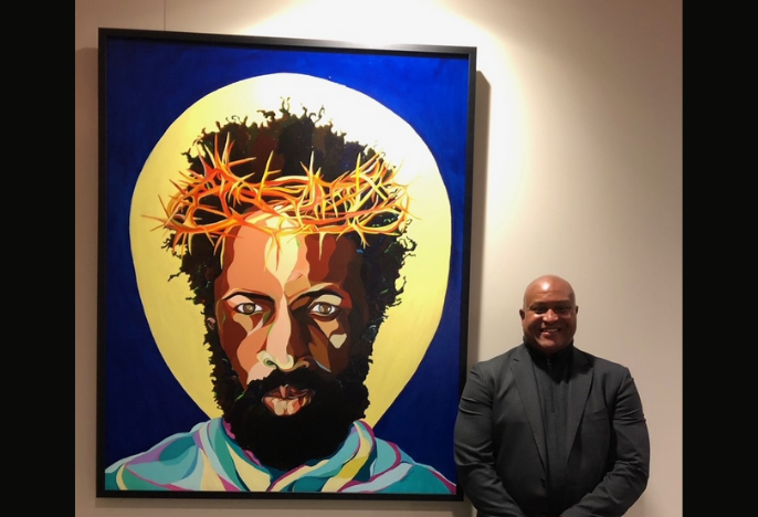 Artist Gerald Roulette standing next to painting of Black Christ, The Great I Am
