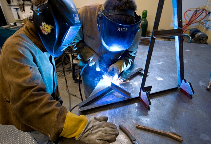 Student welding materials together