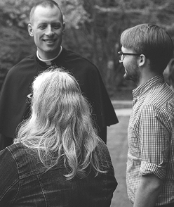 Priest talking with students