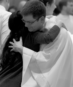 Priest giving sign of peace to parishoner