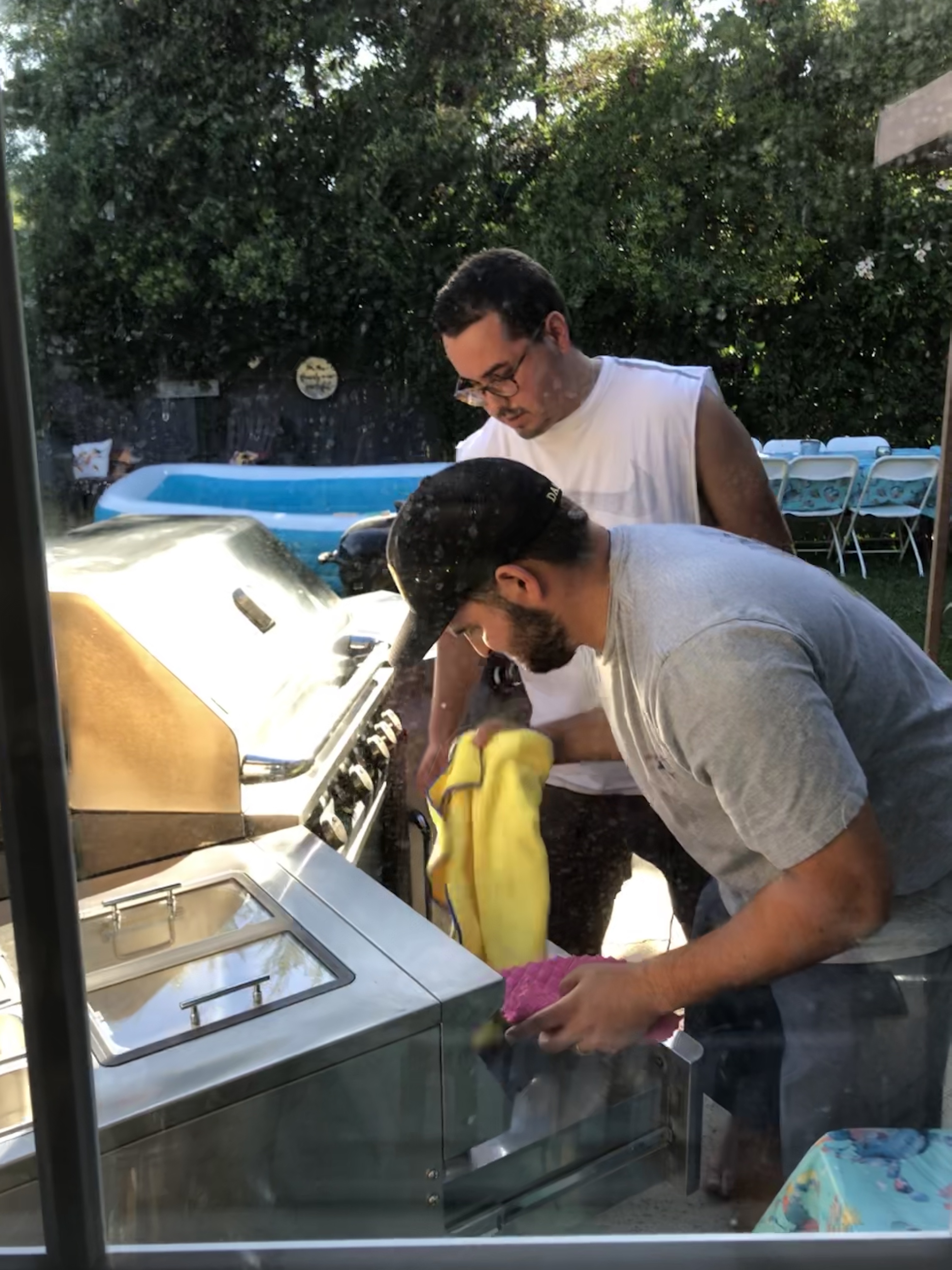 Brothers Dominic and David making the final buffs to the grill they had worked hard to clean up, right before they called their dad over to surprise him with it.