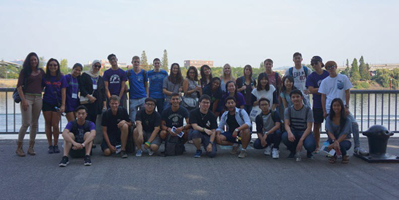 International students pose in front of the water front in downtown Portland