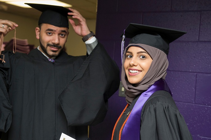 A male and female student in graduation cap and gown