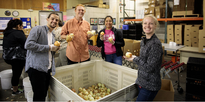 Students on the Rural Immersion smiling and volunteering at a food bank