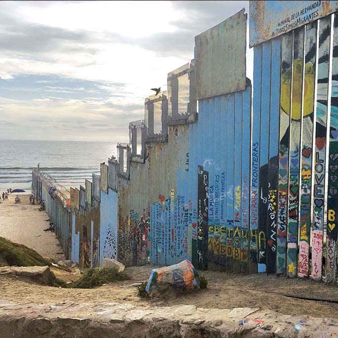 Border wall leading into the ocean.