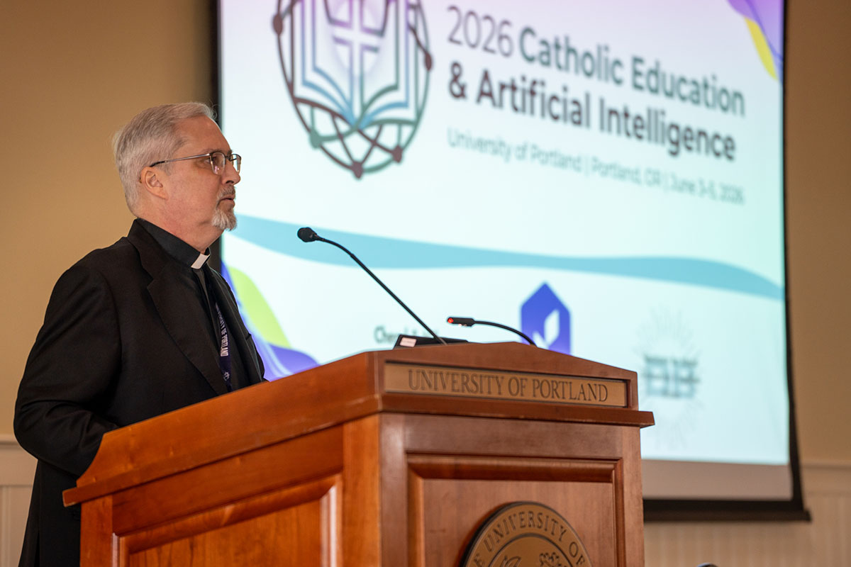 philip larrey stands behind the podium at the ai conference