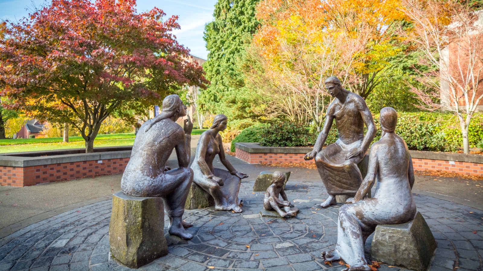 An image of the sculptural group commemorating Fr. Oddo surrounded by trees.