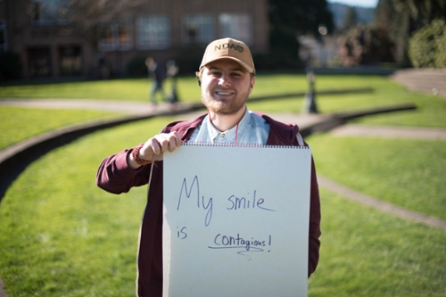 boy holding sign that reads, "my smile is contagious"