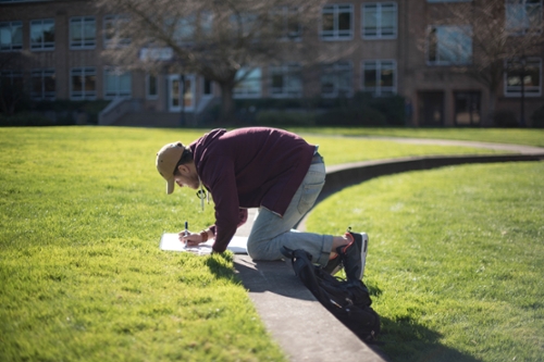 boy writing on large paper