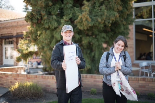 boy holding sign, girl laughing