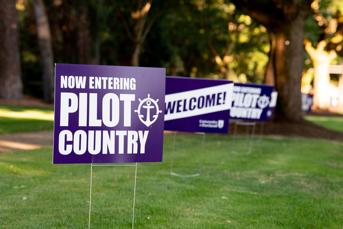 Purple yard signs with welcoming messages for Pilots on The Bluff.