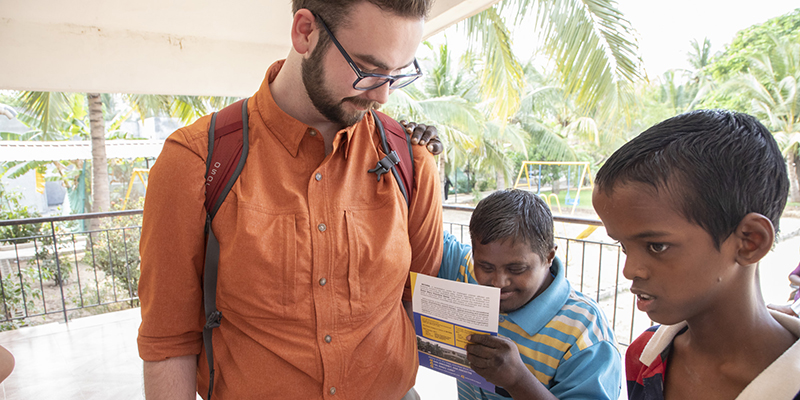 photo of man with two students in India