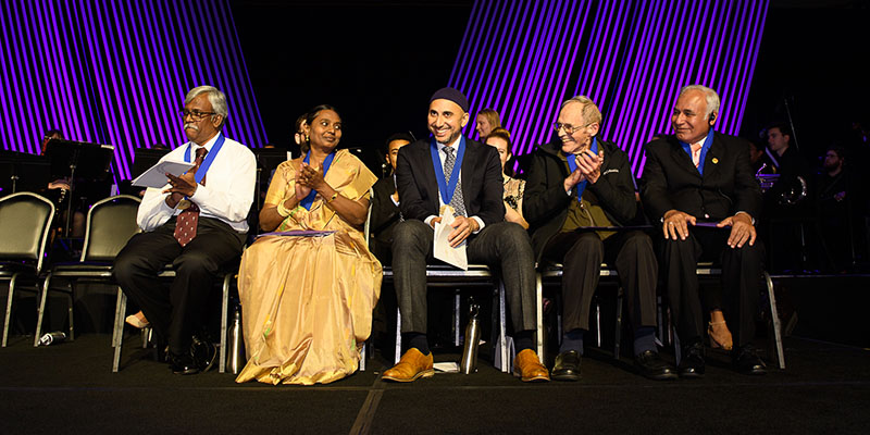 group of 5 people sitting on stage