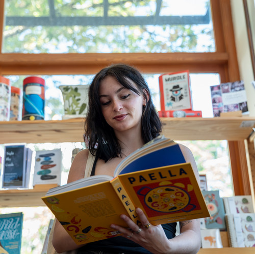 A student peruses a book in Powells