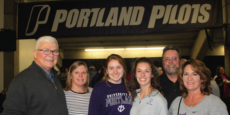 photo of 2 families under Portland Pilots sign