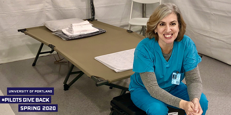 Jennifer Graves sitting in nursing scrubs with logo that reads University of Portland Pllots Give Back Spring 2020