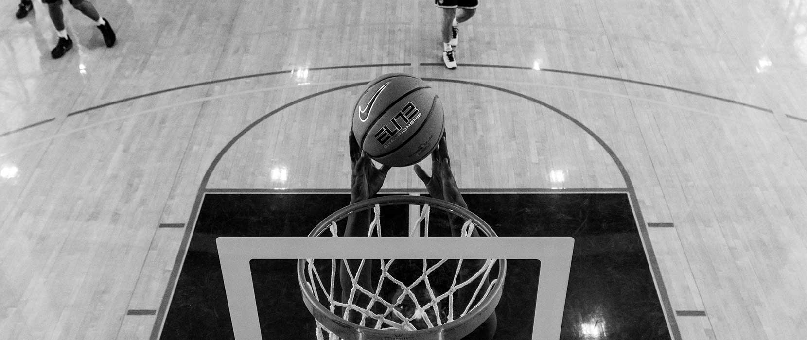 black and white photo of a player dunking the ball