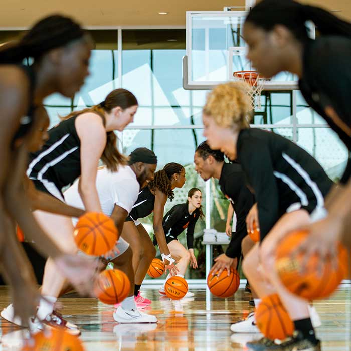 two lines of femal basketball players dribble the ball