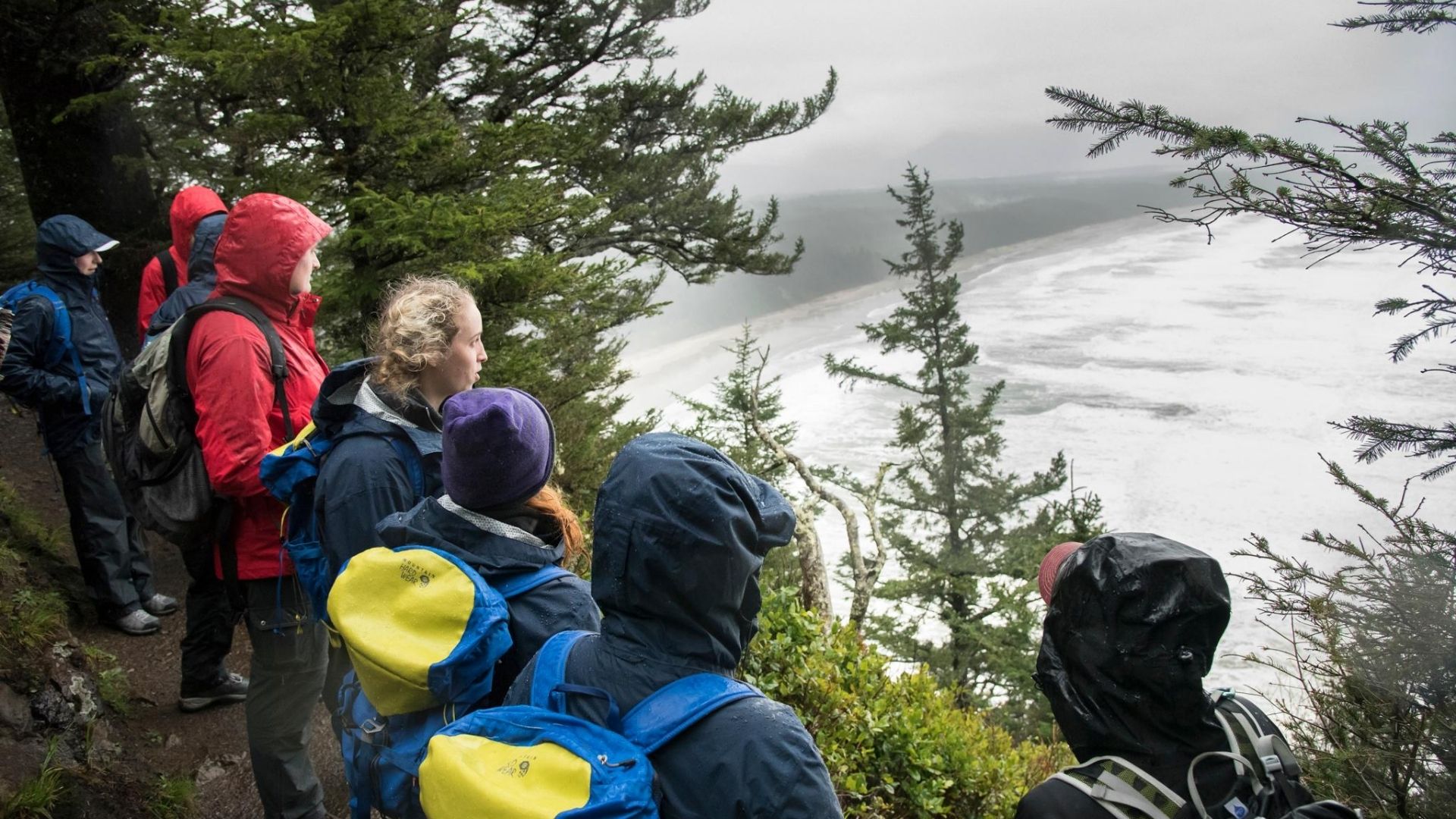 College group in rain jackets on hike at Oregon Coast