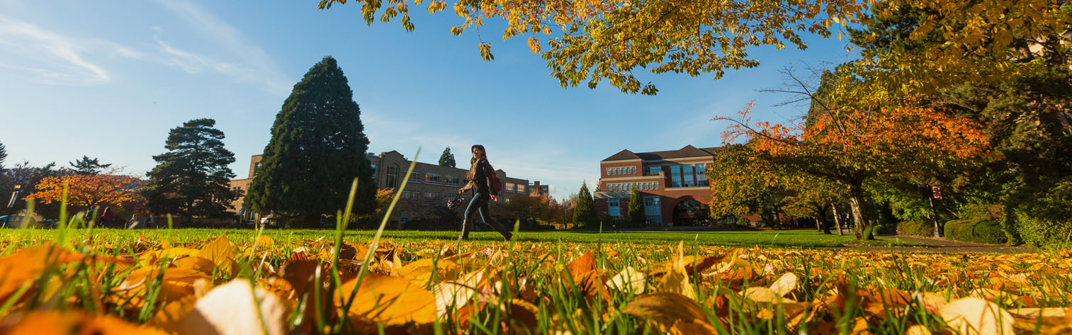 student walking through campus in the fall. 