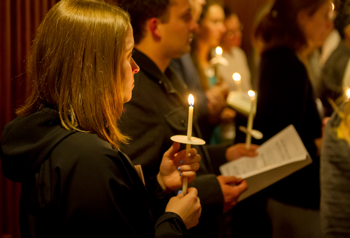 Photo of students holding candles in worship service on campus.