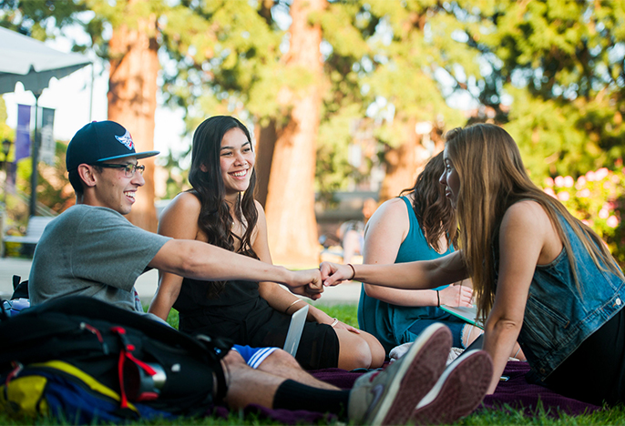 Students fist bump each other outside