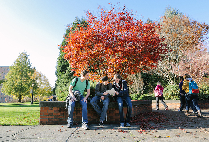 This is a photo of three students sitting outside Franz Hall. 