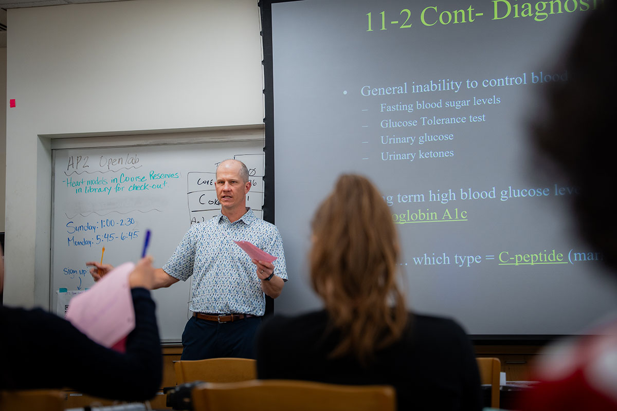 A professor lectures in front of biology class