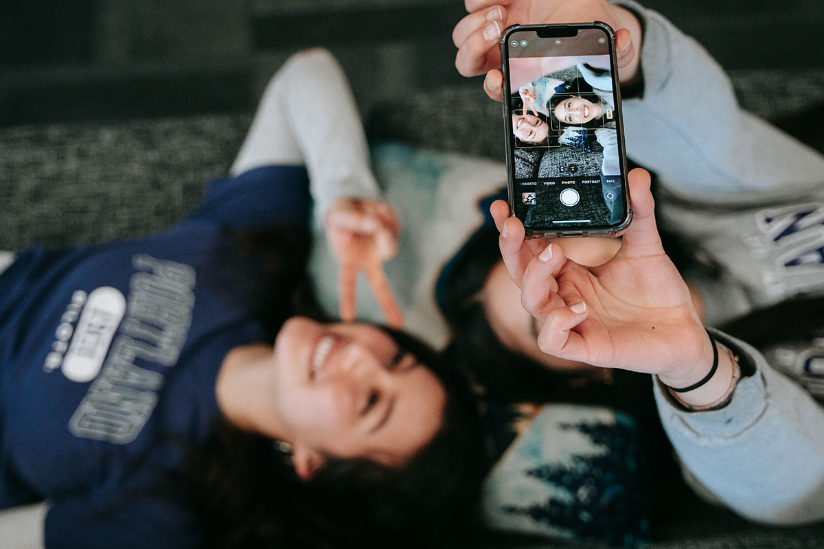 students take a selfie on the couch in the lund hall lounge