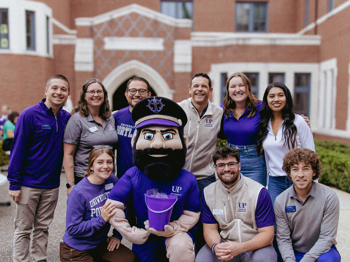 A group of University of Portland staff members pose with UP's mascot, Wally, in front of Lund Family Hall on move-in day.