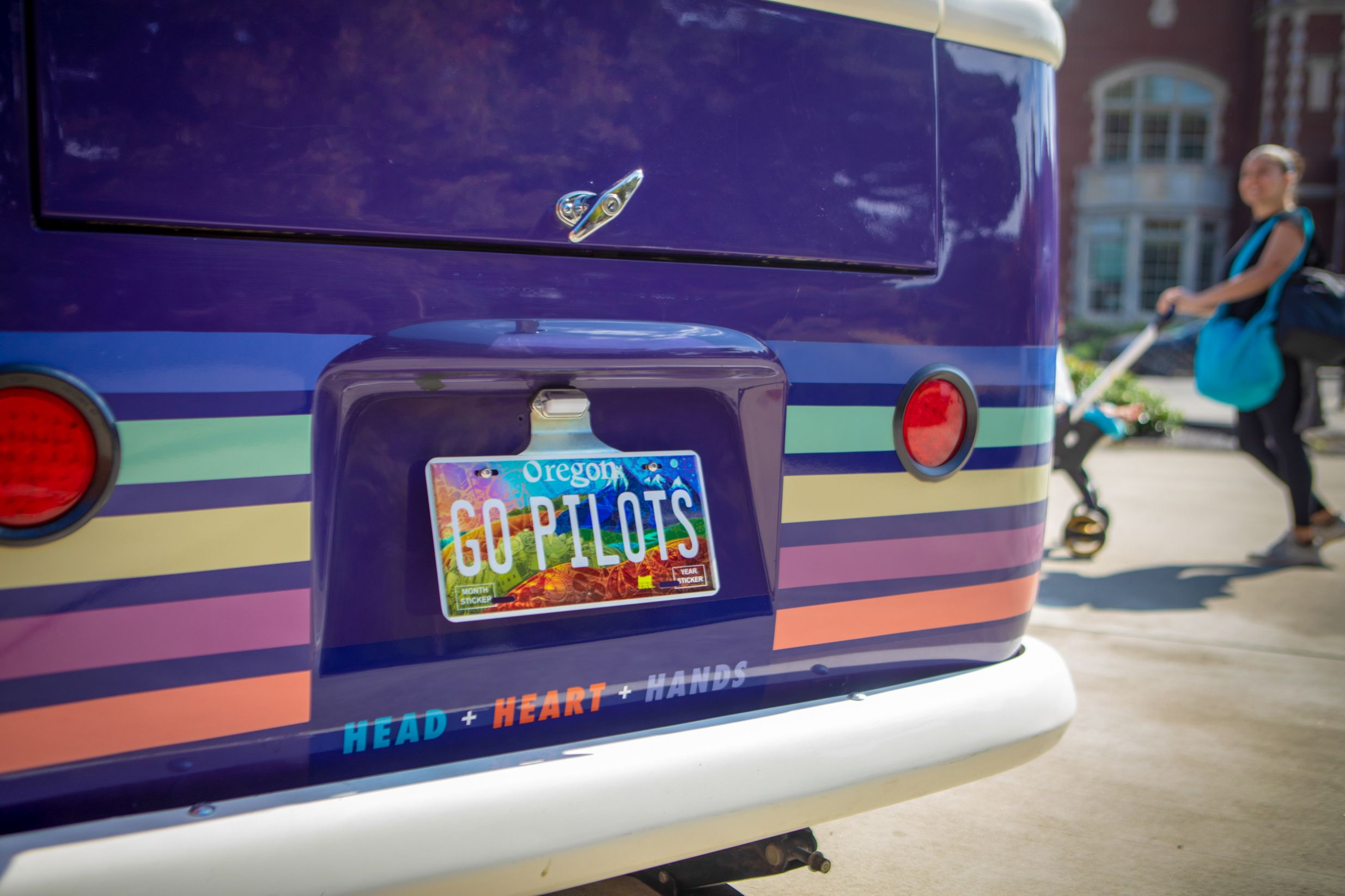 A close-up image of the back end of a colorful car with a license plate that says "Go Pilots"