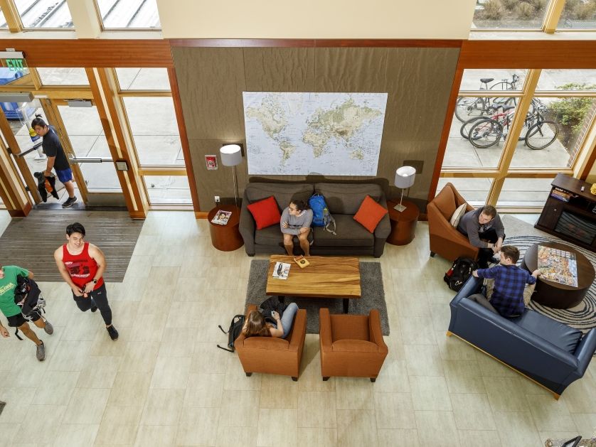 An overhead image of students interacting in the gathering space of a dormitory common area.