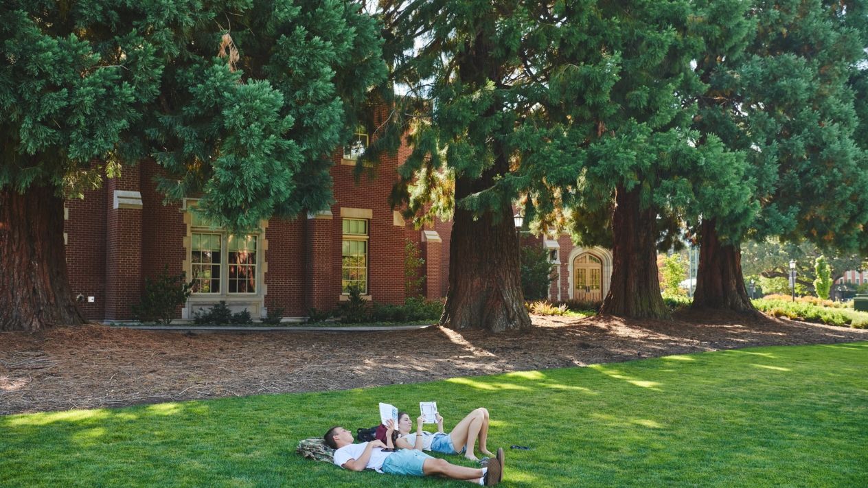 Students lying down in the grass on campus
