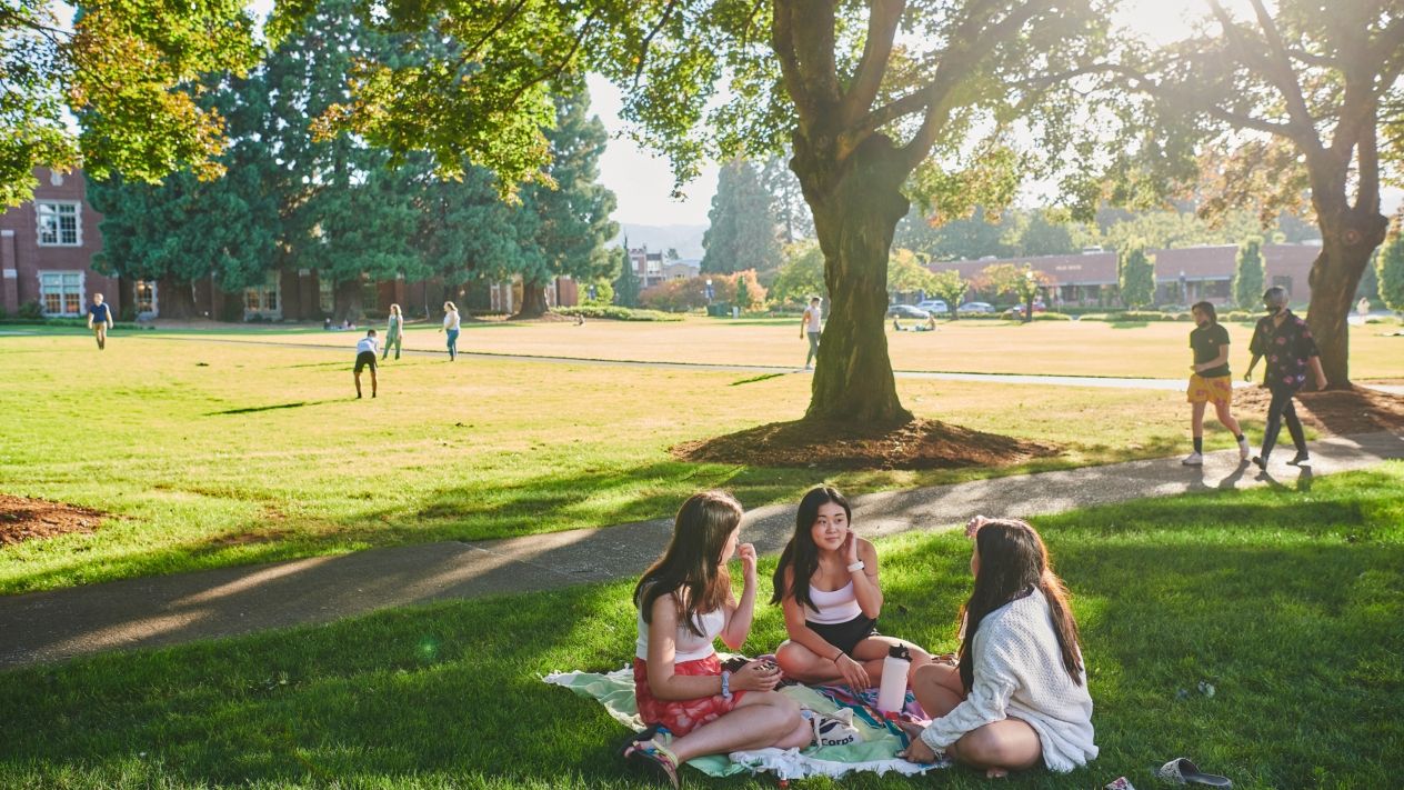 A wide angle shot of a UP quadrangle with students engaged in various social and athletic activities.