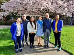 OIEDI staff in front of cherry blossoms