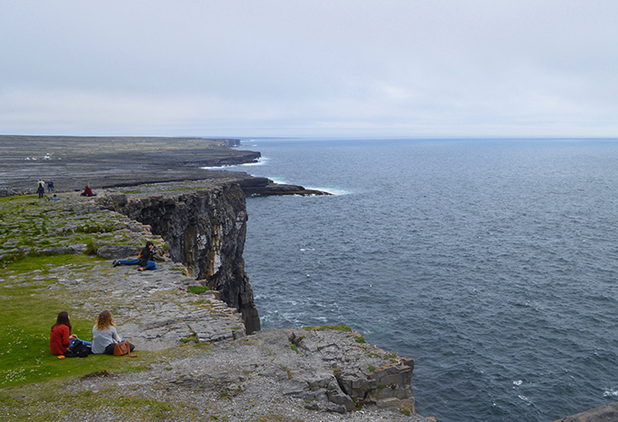 Students on cliffs above the ocean