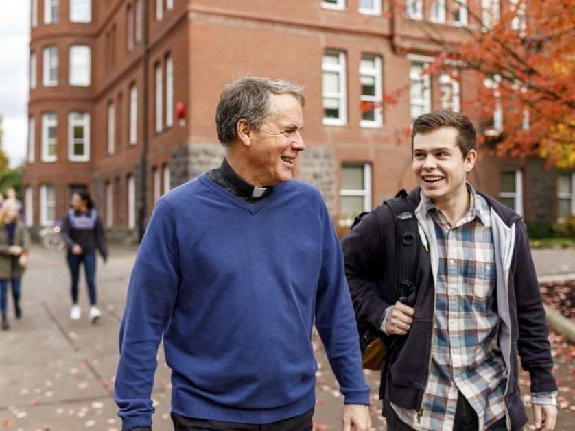 A priest and student engaged in conversation.